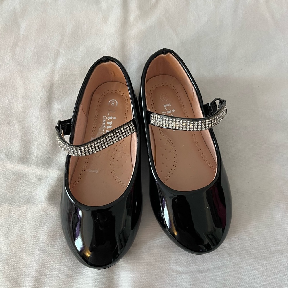 Little girl’s slightly worn dressy shoes